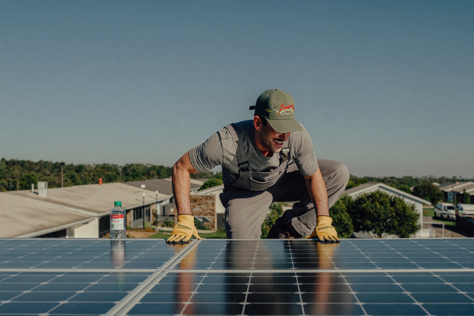 An installer fitting solar panels on a residential rooftop